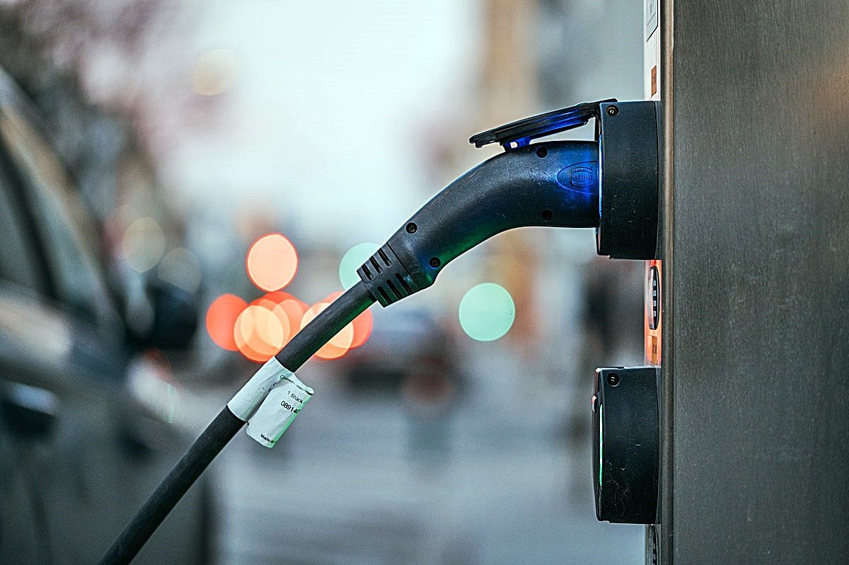 Close up of an electric car charging station with a car plugged in